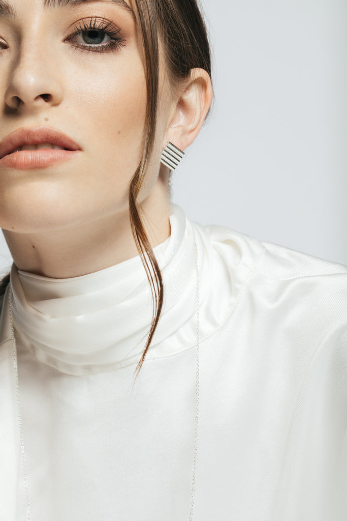Model wearing contemporary square shape silver earrings.