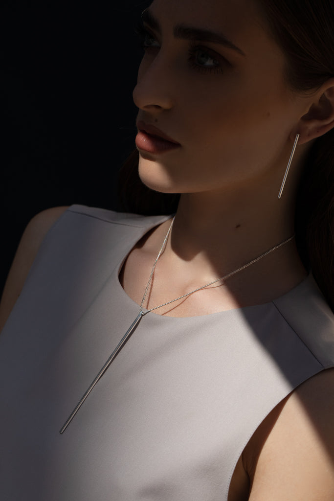 Minimalist long tube silver earrings and necklace.