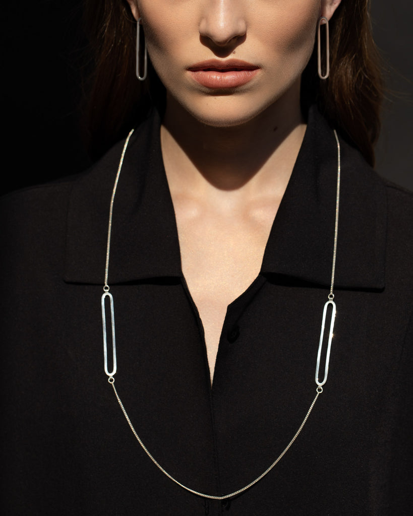 Minimalist statement necklace with two long oval pendants.