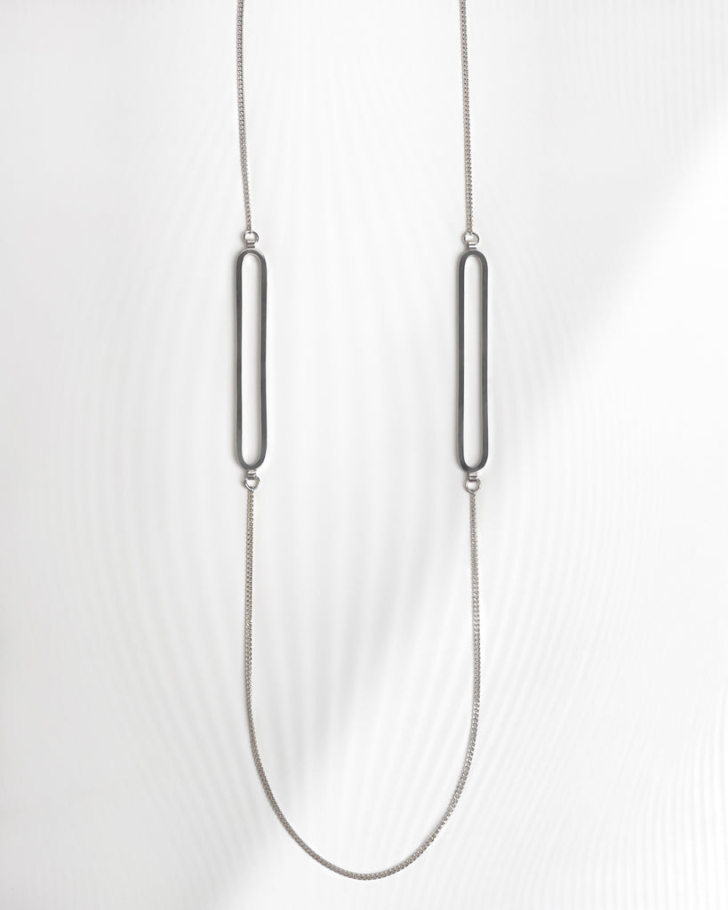 Minimalist statement necklace with two long oval pendants.